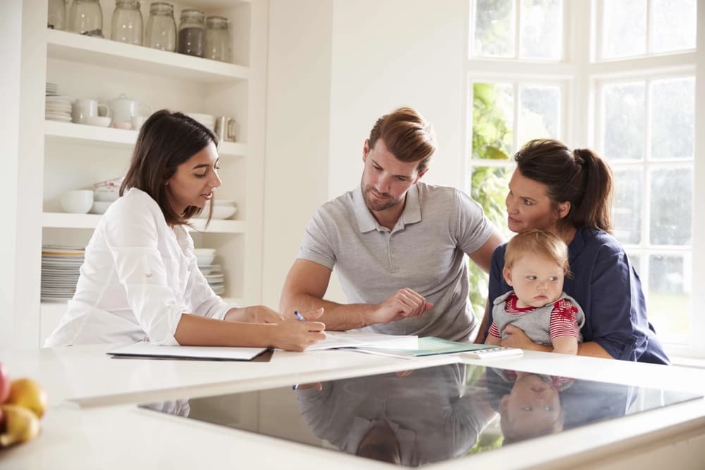 Female financial advisor helping young couple with baby
